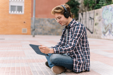 young man watching some videos with wireless headphones