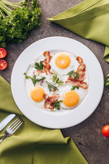Toasted eggs with bacon on a white dish.