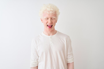 Young albino blond man wearing casual t-shirt standing over isolated white background sticking tongue out happy with funny expression. Emotion concept.