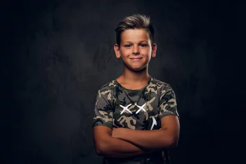 Foto op Plexiglas Little charming boy with nice hairstyle is posing over dark background at photo studio. © Fxquadro