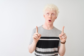 Young albino blond man wearing casual t-shirt standing over isolated white background amazed and...