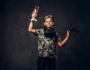 Little proud champion just won the competition in virtual reality games and got the cup.