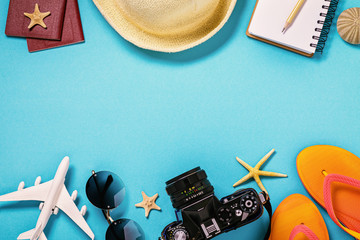 Various beach accessories on a blue background with copy space, top view. Vacation and travel concept
