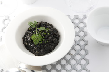 arroz negro con calamares y perejil., vista  cenital. black rice with squid and parsley.