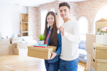 Fototapeta na wymiar Young asian couple holding keys of new house, smiling happy and excited moving to a new apartment