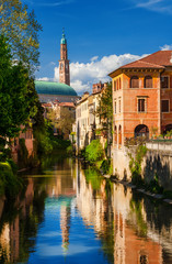 Fototapeta na wymiar Wonderful renaissance Basilica Palladiana seen from River Retrone with reflection in Vicenza historic center