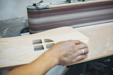 A man carves a tree. The carpenter works in a studio. An engineer provides a tree shape