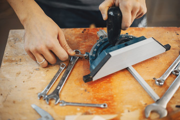 A man carves a tree. The carpenter works in a studio. An engineer provides a tree shape