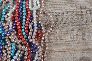 Frame of colorful beads on textured wooden background