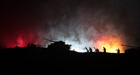 Naklejka na ściany i meble War Concept. Military silhouettes fighting scene on war fog sky background, World War German Tanks Silhouettes Below Cloudy Skyline At night. Attack scene. Armored vehicles and infantry.