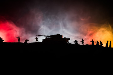 Obraz na płótnie Canvas War Concept. Military silhouettes fighting scene on war fog sky background, World War German Tanks Silhouettes Below Cloudy Skyline At night. Attack scene. Armored vehicles and infantry.