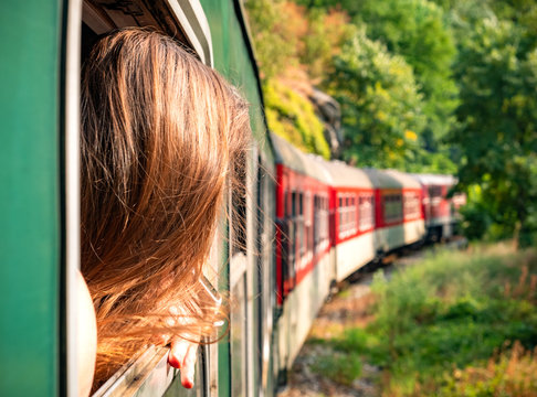 Woman looking out the window of the old train. Bulgarian mountains, Alpine railway in the Balkans