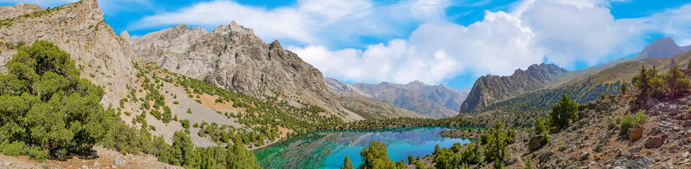 Fototapeta na wymiar Panoramic view of Alaudin lake with turquoise water on a rocky mountain background. Fann Mountains,Tajikistan, Central Asia