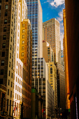Narrow street with high buildings of Wall Street District in New York City