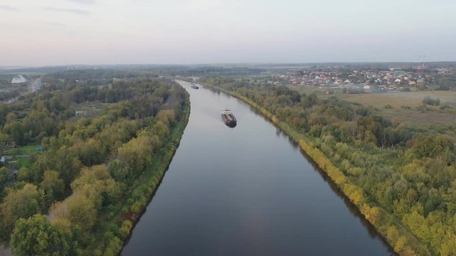 Air view of the movement of the barge on the shipping channel in the area of locks and construction of the bridge