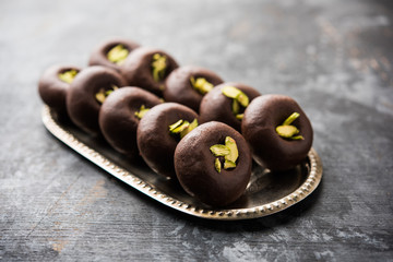 Chocolate Milk peda or pera or pedha made using sweet condensed Milk and cocoa powder, garnished with Pistachio. selective focus