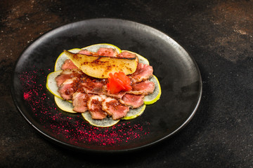carpaccio meat duck and pear (savory snack, gourmet cuisine) menu concept. food background. copy space. Top view