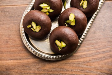 Chocolate Milk peda or pera or pedha made using sweet condensed Milk and cocoa powder, garnished with Pistachio. selective focus