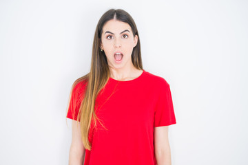 Fototapeta premium Young beautiful woman wearing casual red t-shirt over white isolated background afraid and shocked with surprise expression, fear and excited face.