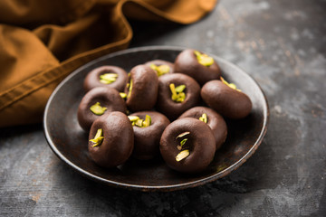 Chocolate Milk peda or pera or pedha made using sweet condensed Milk and cocoa powder, garnished with Pistachio. selective focus