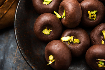 Chocolate Milk peda or pera or pedha made using sweet condensed Milk and cocoa powder, garnished with Pistachio. selective focus