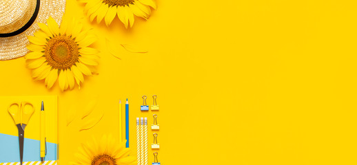 Top view flat lay of workspace desk styled design with sunflowers, straw hat, notebook, diary,...