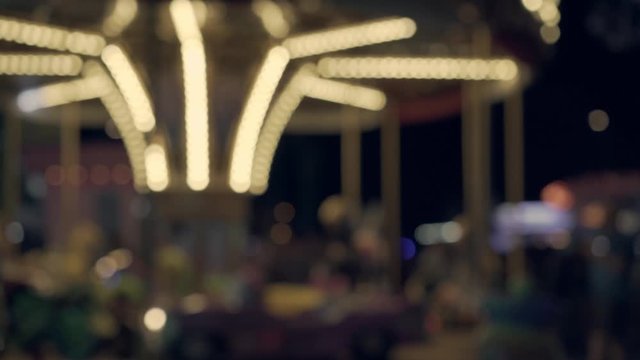 Night view of the carousel in an amusement park. Happy childhood. Rest, joy for children