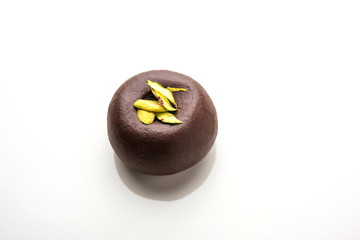 Chocolate Milk peda or pera or pedha made using sweet condensed Milk and cocoa powder, garnished with Pistachio. selective focus