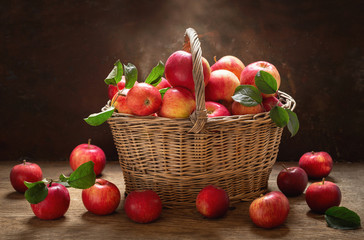 fresh apples with leaves in a basket