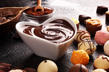 a lot of variety chocolate pralines, belgian confectionery gourmet chocolate on rustic dark background