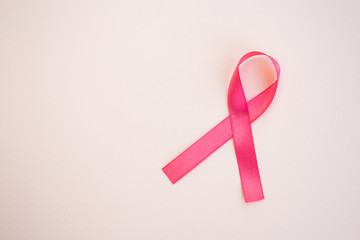 Pink breast cancer awareness ribbon on a light pink background. Medicine and healthcare concept, women's health. Copy space