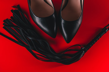 sex toys concept. black sexy fetish high heels. fetish shoes. strict mistress foot wear and bdsm whip - obrazy, fototapety, plakaty