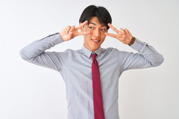 Chinese businessman wearing elegant tie standing over isolated white background Doing peace symbol with fingers over face, smiling cheerful showing victory