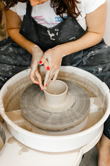 girl makes a product on a pottery wheel
