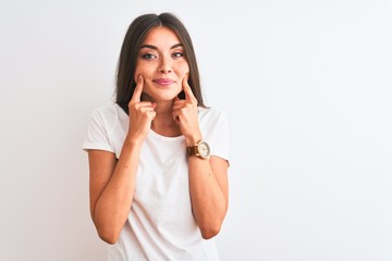 Young beautiful woman wearing casual t-shirt standing over isolated white background Smiling with open mouth, fingers pointing and forcing cheerful smile