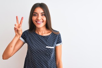 Young beautiful woman wearing blue casual t-shirt standing over isolated white background showing and pointing up with fingers number two while smiling confident and happy.