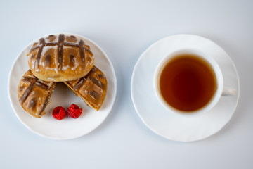 Gingerbread cookies with raspberries and tea on a white background