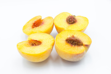 two peaches cut in half with a white background