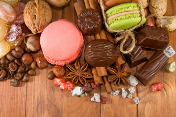 macarons and chocolate candies lie on a wooden surface