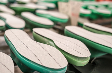 Konzept Schuhproduktion: Auswahl an Zwischensohlen unterschiedlicher Größe fertig zur...