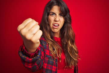 Young beautiful woman wearing casual jacket standing over red isolated background Showing middle finger doing fuck you bad expression, provocation and rude attitude. Screaming excited