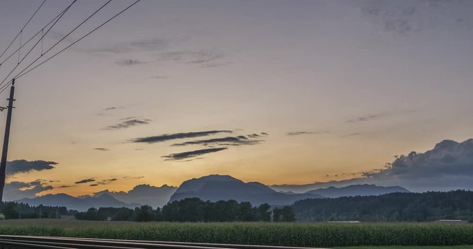 4k time lapse zoom in countryside farming field are during sunset with train tracks