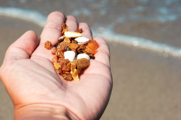 Amber stones in the palm. Raw amber in the hand.