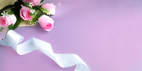Mothers day, Womens day, Valentines day, birthday or wedding concept. Silk ribbon, pink rose on grey background.  Selective focus. Place for text.