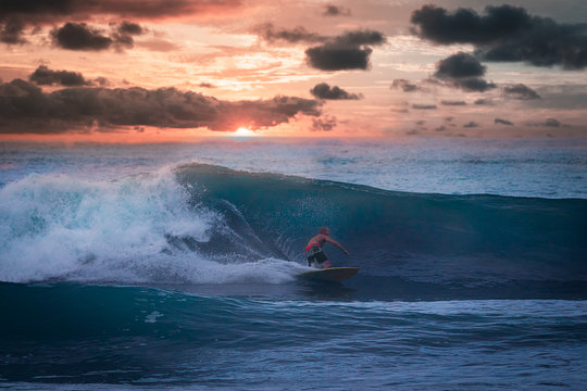 Hombre surfea espectacular ola con atardecer de fondo en Colombia.