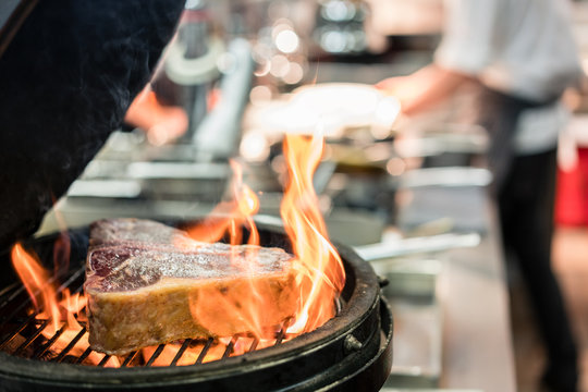 Close-up of a steak on a burning grill in the kitchen of a restaurant with high quality food