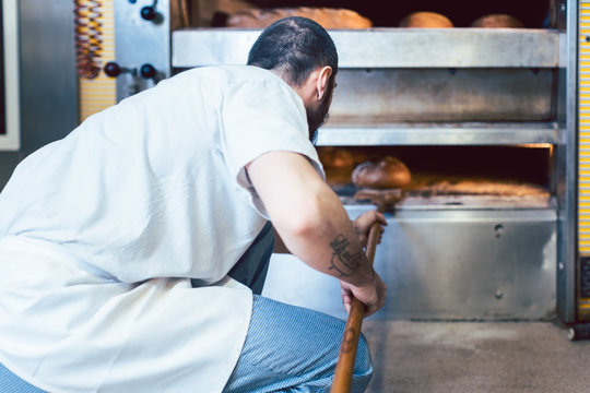 Baker checking bread in the baker oven
