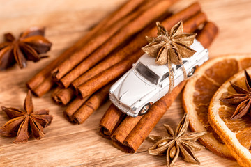 Christmas card with toy car and cinnamon on black background