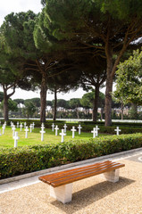 Bench next to the crosses of soldiers' graves fallen in World War II. Nettuno, Italy