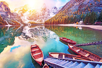 Fantastic autumn landscape with boats on the lake with sunrise on Fanes-Sennes-Braies natural park in the Dolomites in South Tyrol, Alps, Italy. Exotic amazing places. (harmony - concept)